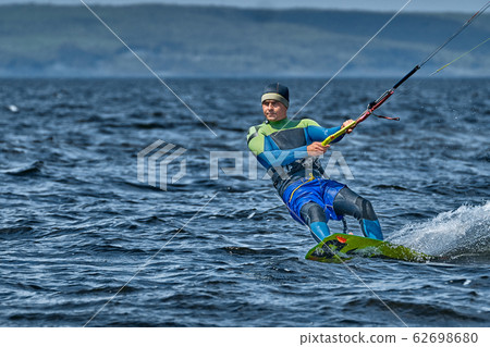 A male kiter slides on the surface of the water. A male kiter slides on the surface of the water. 62698680