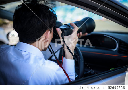 A man taking a picture from inside the car 62699238