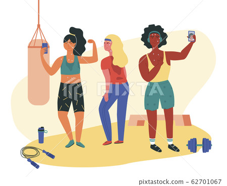 Three females doing sweaty selfie check-ins during gym session. Asian, black and white girls working out at fitness class with jump rope, dumbell, punching bag, platform. Functional training. 62701067