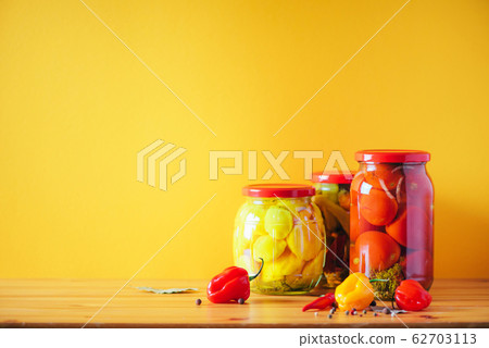 Сucumber, squash and tomatoes pickling and canning into glass jars. Ingredients for vegetables preserving. Healthy fermented food concept. Harvest storing 62703113