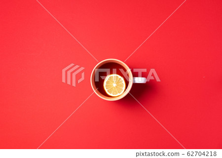 Cup of tea with lemon on red background. Top view. Copy space. Banner. Autumn or winter season concept 62704218