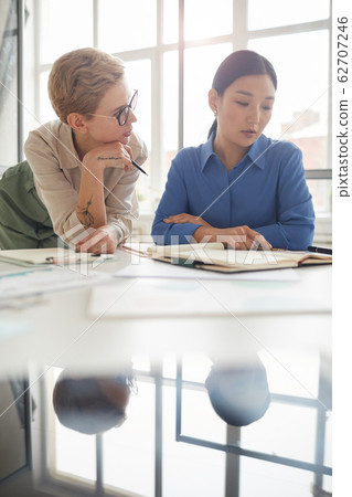 Businesswomen Discussing Work in Siunlit Office 62707246