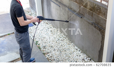 A man cleaning with a high pressure washer 62708635