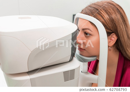 Measuring young woman's eye pressure with tonometer 62708793