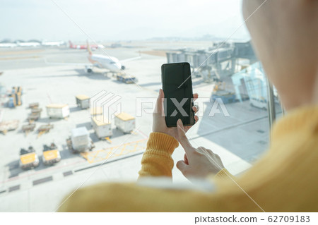 Woman hand hold smartphone at airport 62709183