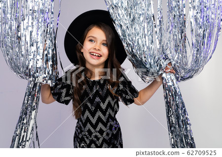 happy surprised teenage girl in a black hat and elegant dress peeks out from behind curtains made of happy surprised teenage girl in a black hat and elegant dress peeks out from behind curtains made of 62709525
