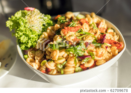 Pasta with fresh vegetables on white plate Pasta with fresh vegetables on white plate 62709678