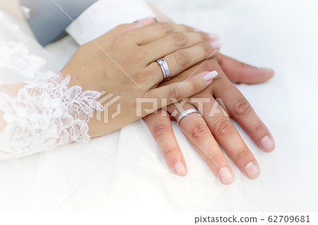 Hands and rings on wedding bouquet Hands and rings on wedding bouquet 62709681