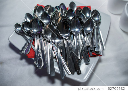 Stack of shining spoon, Abstract background of sparkling bronze spoon, kitchen equipment, Row of silver spoon background, Glittering light from kitchen equipment Stack of shining spoon, Abstract background of sparkling bronze spoon, kitchen equipment, Row of silver spoon background, Glittering light from kitchen equipment 62709682