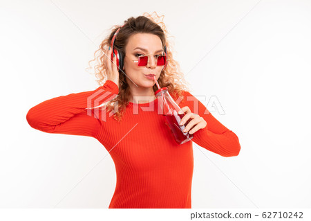 Beautiful caucasian woman drinks red juice 62710242