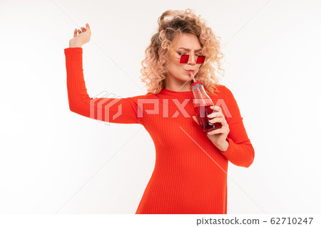 Beautiful caucasian woman drinks red juice Beautiful caucasian woman drinks red juice 62710247