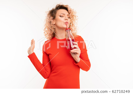 Beautiful caucasian woman drinks red juice Beautiful caucasian woman drinks red juice 62710249