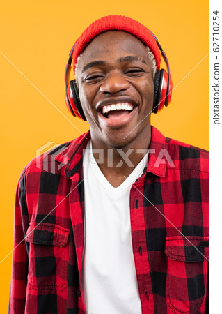 handsome smiling black american man listening to music using headphones handsome smiling black american man listening to music using headphones 62710254