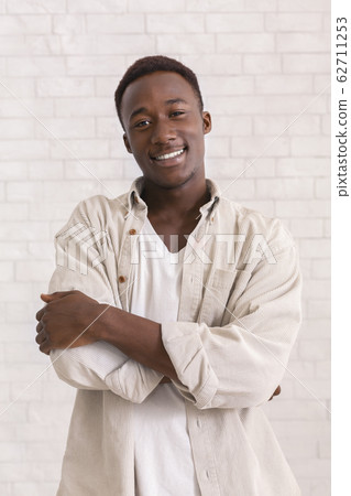 Cute carefree black guy smiling over white background Cute carefree black guy smiling over white background 62711253