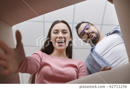 Woman and man are looking into box 62711256