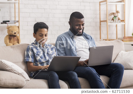 Happy Afro Father And Son Playing Video Games On Laptops Together Happy Afro Father And Son Playing Video Games On Laptops Together 62711530