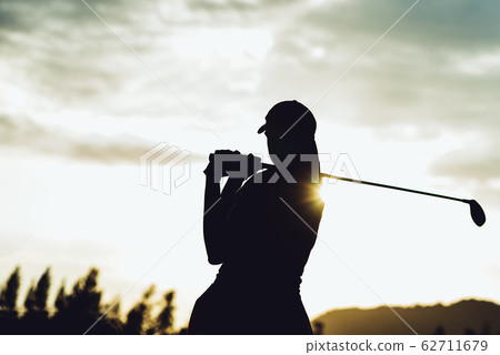 Silhouette of  young professional female golf player hit sweeping and keep golf course doing golf swing,she does exercise for relax time 62711679