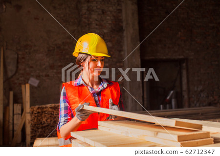Woman worker sorting wood at production factory. Gender equality concept. 62712347