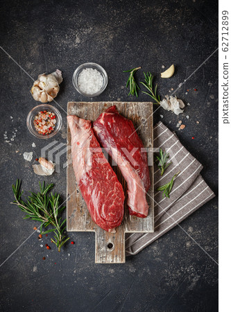 Raw beef steak with spices. 62712899