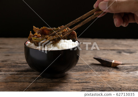 White rice in black bowl with spicy eel on wooden White rice in black bowl with spicy eel on wooden 62713035