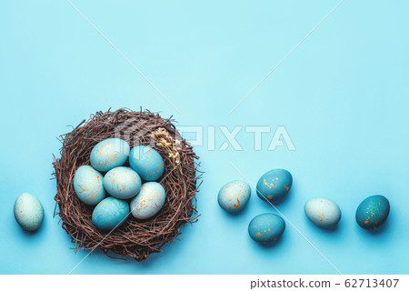 Easter eggs in nest on blue background. 62713407