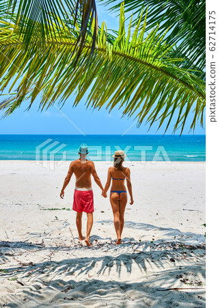 Couple walking on a tropical beach 62714175