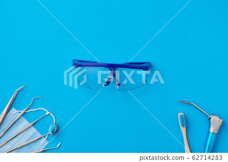 Dentist tools over blue background top view 62714283