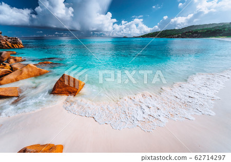 Gentle foam wave on Grand Anse beach, La Digue, Seychelles. White clouds, crystal clear ocean vacation holiday scene 62714297