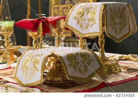 Holy Communion. Golden Chalices with the sanctified Body and Blood of Christ on the Holy See, covered with white covers. Christmas Divine Liturgy in Orthodox Church Holy Communion. Golden Chalices with the sanctified Body and Blood of Christ on the Holy See, covered with white covers. Christmas Divine Liturgy in Orthodox Church 62714385