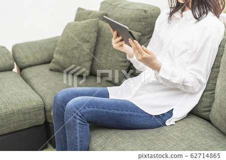 女人在客廳裡操作平板電腦 女人在客廳裡操作平板電腦 62714865
