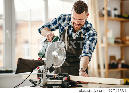 young male carpenter working in workshop. young male carpenter working in workshop. 62714884