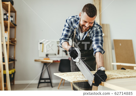 young male carpenter working in  workshop. 62714885