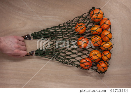 mandarins in green net bag zero waste concept 62715384