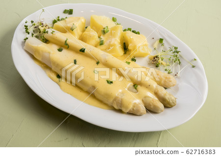 white asparagus poured with hollandaise sauce 62716383