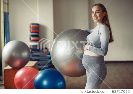 Pregnant woman training in a gym Pregnant woman training in a gym 62717033