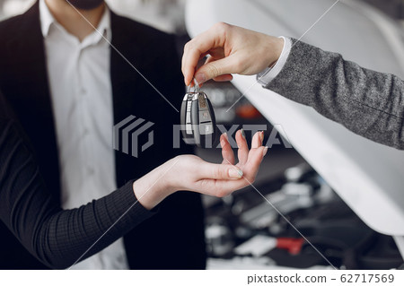 Stylish and elegant couple in a car salon Stylish and elegant couple in a car salon 62717569