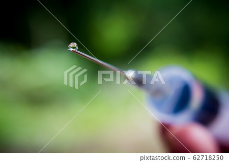 Syringe with needle on blur background Syringe with needle on blur background 62718250