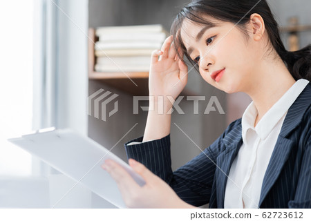A business woman reading the document in the office 62723612