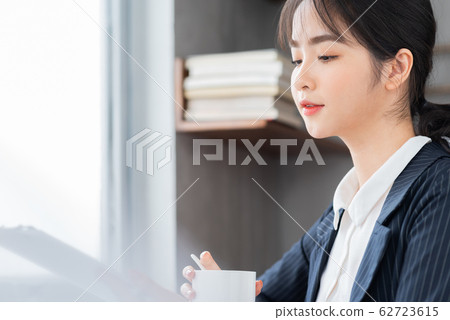 A business woman reading the document in the office A business woman reading the document in the office 62723615