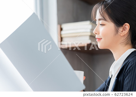 A business woman reading the document in the office A business woman reading the document in the office 62723624