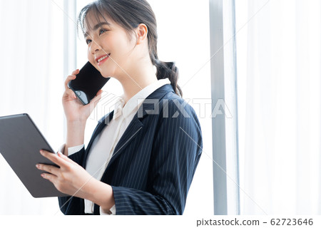 A business woman calling beside the window 62723646
