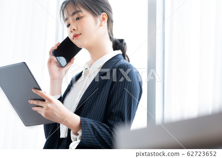 A business woman using tablet beside the window 62723652