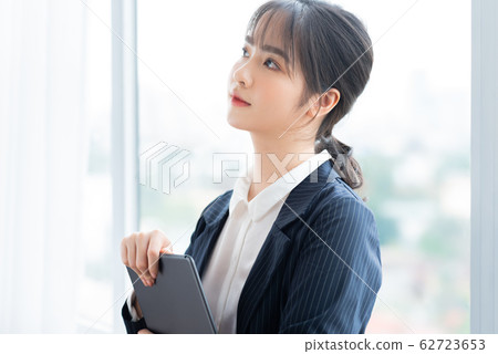 A business woman using tablet beside the window A business woman using tablet beside the window 62723653