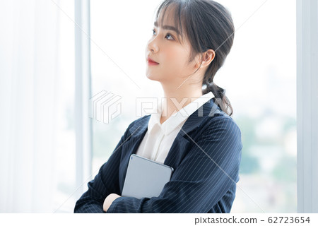 A business woman using tablet beside the window A business woman using tablet beside the window 62723654