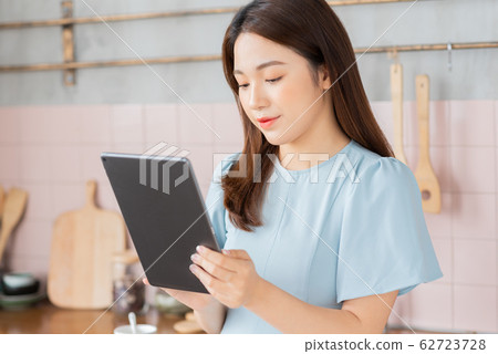 A beauty woman using a tablet in the kitchen 62723728