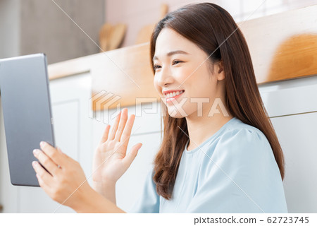 A beauty woman using tablet in the kitchen A beauty woman using tablet in the kitchen 62723745