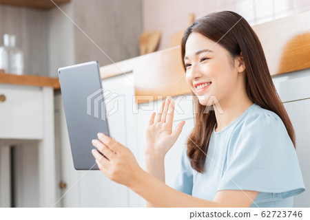 A beauty woman using tablet in the kitchen A beauty woman using tablet in the kitchen 62723746