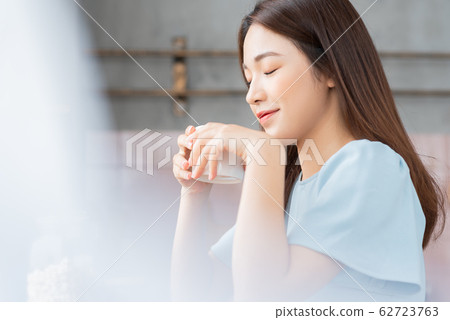 A beauty woman drink coffee by the window  62723763