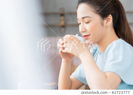 A beauty woman drink coffee by the window A beauty woman drink coffee by the window 62723777