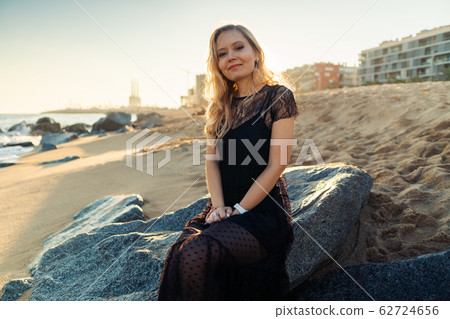 Young woman walking at beautiful ocean beach on sunset 62724656